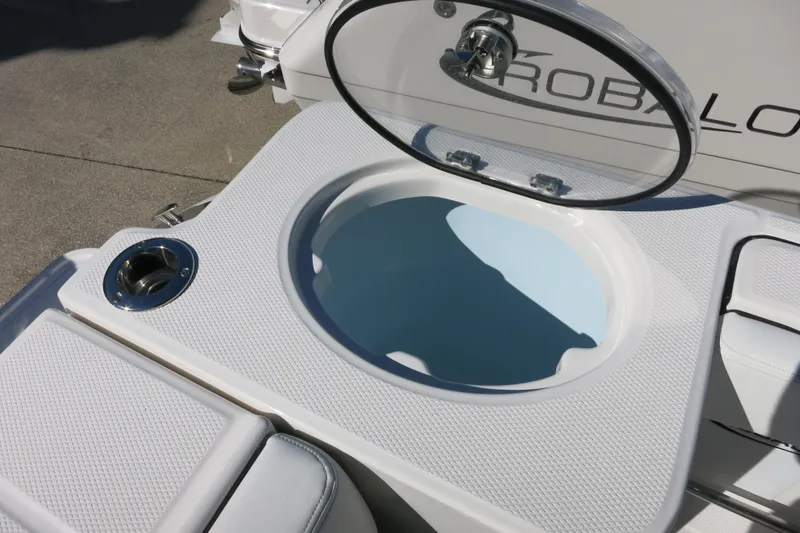 Slide: The Image of 2026 Robalo R230 Center Console livewell with open lid and textured surface. - 12