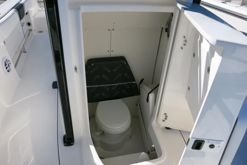 Slide: The Image of 2026 Robalo R230 Center Console boat interior with compact marine toilet. - 18
