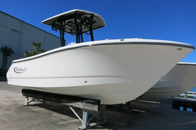 Slide: The Image of 2026 Robalo R230 Center Console boat displayed outdoors on a sunny day. - 2