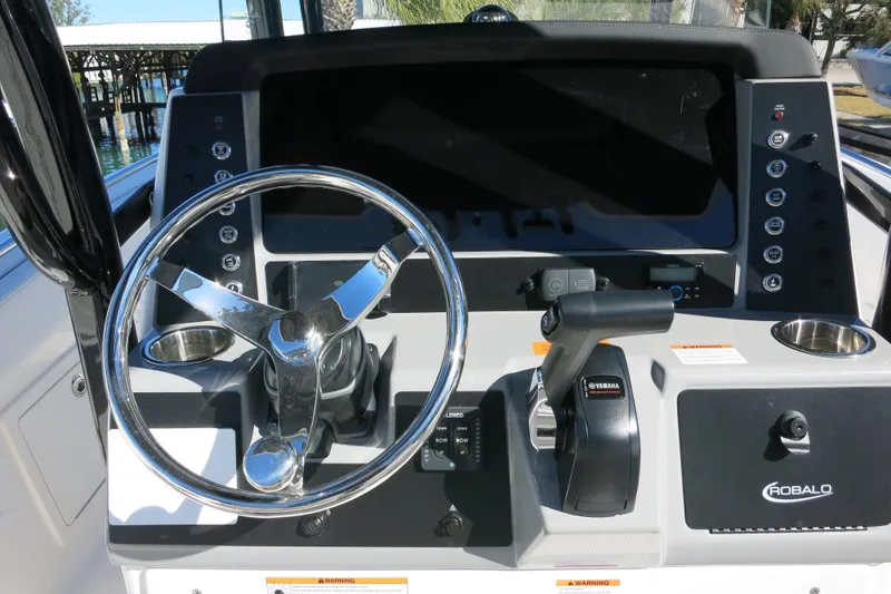 Slide: The Image of 2026 Robalo R230 Center Console helm with steering wheel and controls. - 24