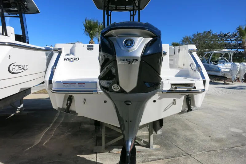 Slide: The Image of 2026 Robalo R230 Center Console boat with powerful outboard motor, displayed outdoors. - 7