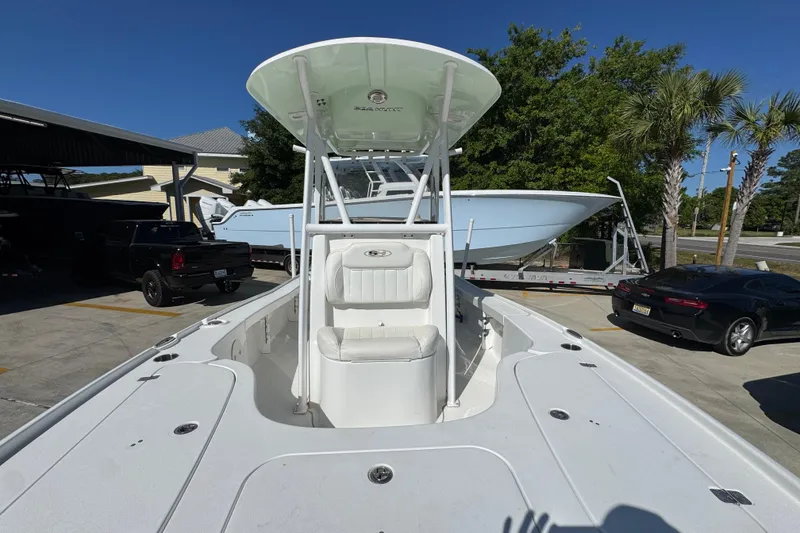 Slide: The Image of 2019 Sea Hunt BX 22 BR boat with T-top, parked outdoors under clear blue sky. - 21