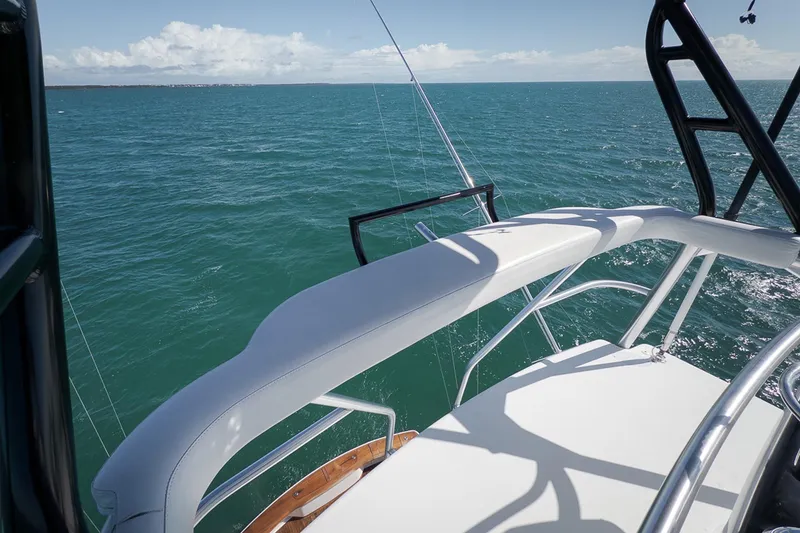 Slide: The Image of 2015 Viking 76 Enclosed Bridge yacht overlooking calm ocean waters. - 15