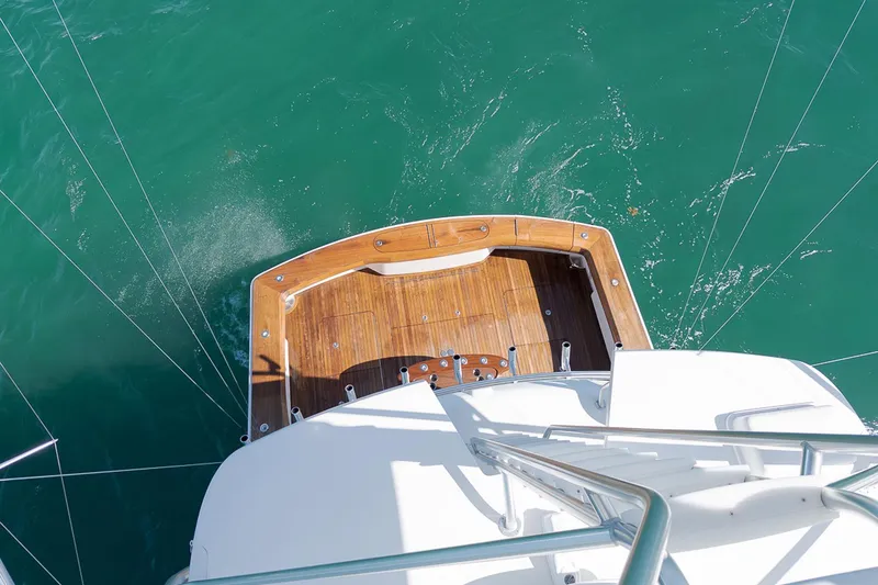 Slide: The Image of Aerial view of 2015 Viking 76 Enclosed Bridge yacht deck on turquoise water. - 16
