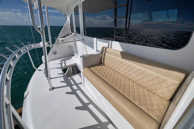 Slide: The Image of 2015 Viking 76 Enclosed Bridge yacht deck with tan seating and ocean view. - 17