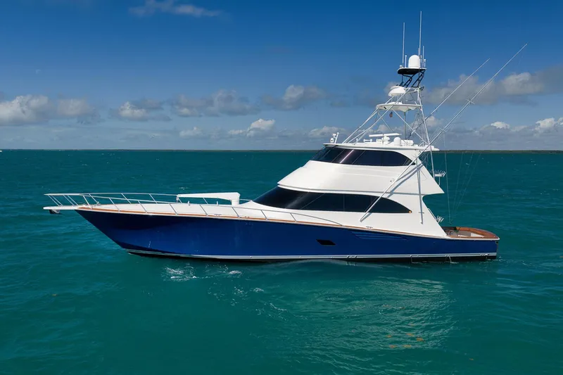 Slide: The Image of 2015 Viking 76 Enclosed Bridge yacht cruising on turquoise waters under a clear blue sky. - 2