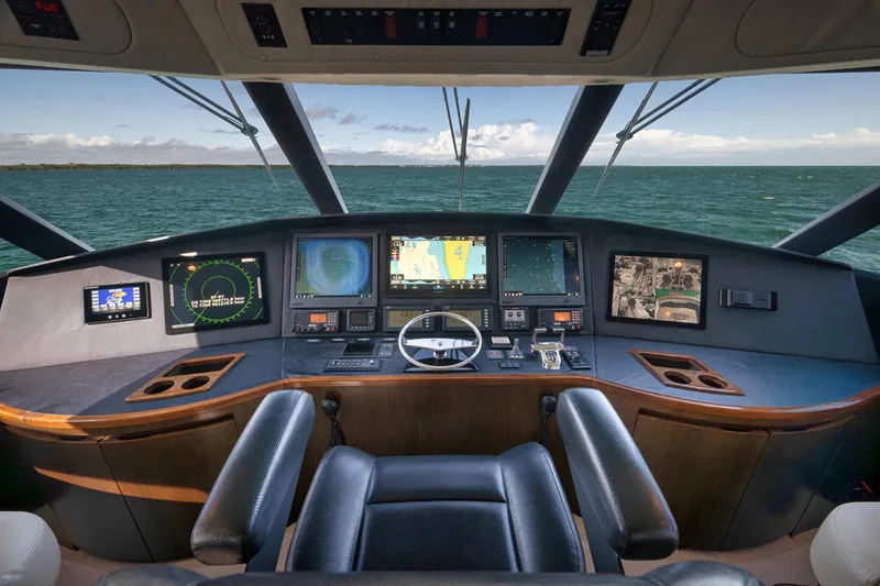 Slide: The Image of Cockpit of 2015 Viking 76 Enclosed Bridge yacht with navigation screens and steering wheel. - 23