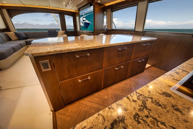Slide: The Image of Luxurious interior of 2015 Viking 76 Enclosed Bridge yacht with granite countertops and ocean view. - 30