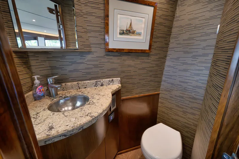 Slide: The Image of Luxurious bathroom on 2015 Viking 76 Enclosed Bridge yacht with granite countertop and modern fixtures. - 32