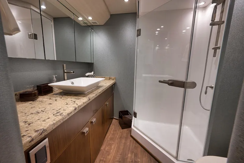 Slide: The Image of Luxurious bathroom in 2015 Viking 76 Enclosed Bridge yacht with modern fixtures and glass shower. - 38