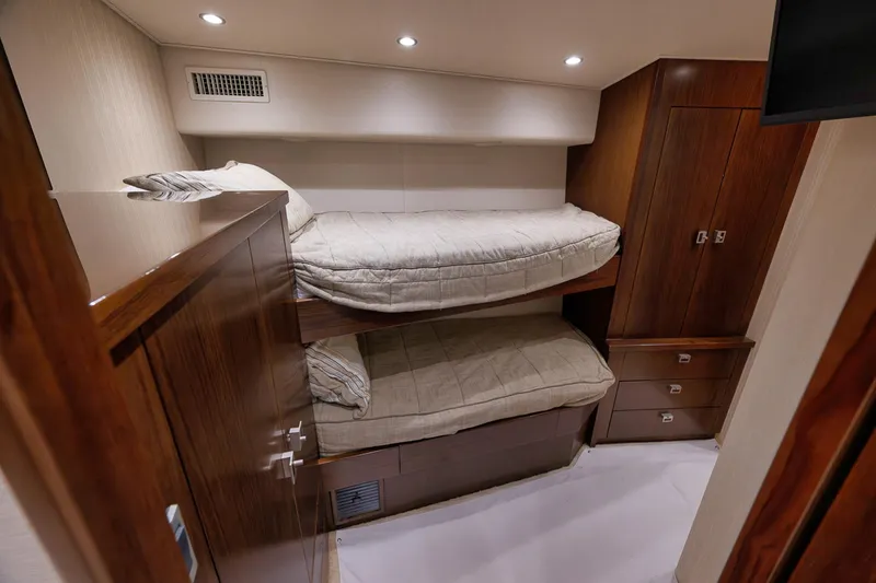 Slide: The Image of Interior of 2015 Viking 76 Enclosed Bridge yacht with bunk beds and wooden cabinetry. - 45
