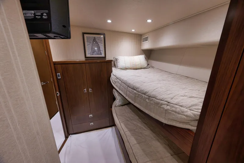 Slide: The Image of Cozy cabin interior of 2015 Viking 76 Enclosed Bridge yacht with bunk beds. - 46
