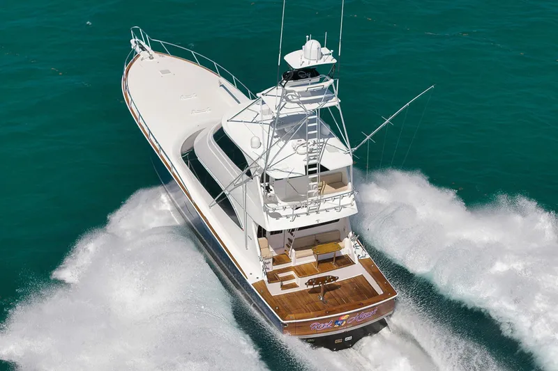 Slide: The Image of 2015 Viking 76 Enclosed Bridge yacht cruising on turquoise waters. - 6