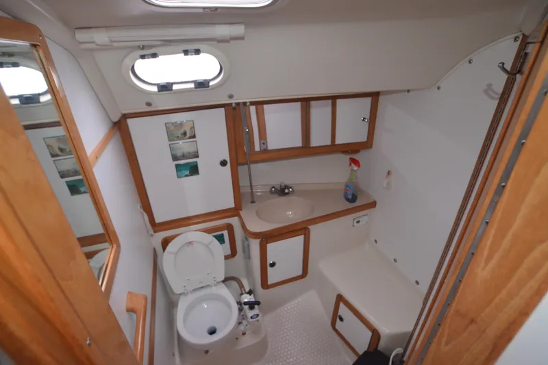 Slide: The Image of Bathroom interior of 2003 Catalina 36 MkII sailboat, featuring sink, toilet, and storage cabinets. - 16