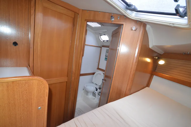 Slide: The Image of Interior of 2003 Catalina 36 MkII sailboat, featuring wooden cabinetry and compact bathroom. - 21