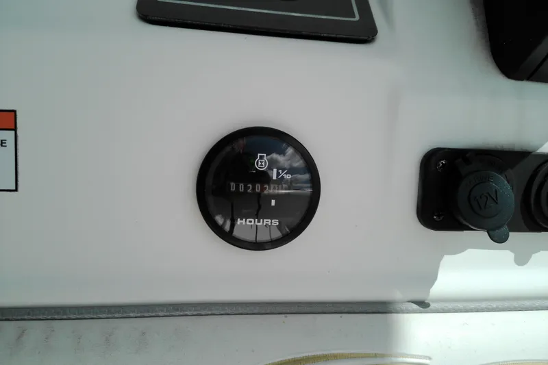 Slide: The Image of Hour meter and 12V outlet on 2023 Glasstream 240 CC boat dashboard. - 11