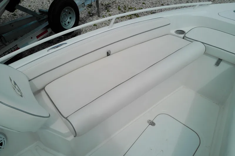 Slide: The Image of 2023 Glasstream 240 CC boat interior with white cushioned seating and storage compartment. - 15