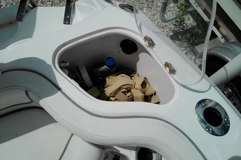 Slide: The Image of Storage compartment on a 2023 Glasstream 240 CC boat with various items inside. - 23
