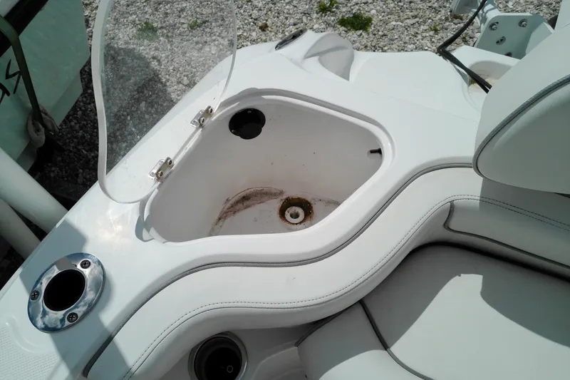 Slide: The Image of Open storage compartment on 2023 Glasstream 240 CC boat, featuring white interior and seating. - 24
