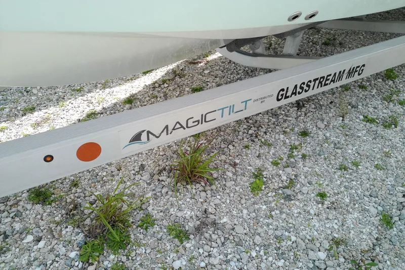 Slide: The Image of 2023 Glasstream 240 CC boat trailer by Magic Tilt on gravel surface. - 3