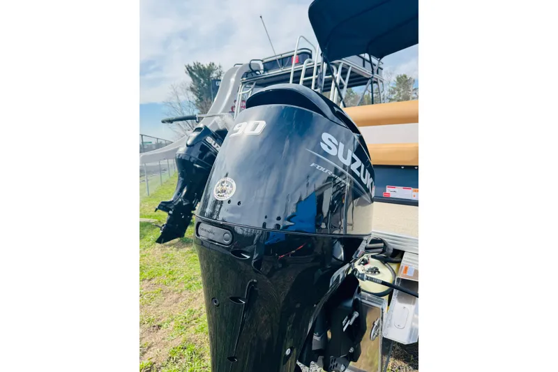 Slide: The Image of 2026 Crest Conquest SE 200 Cruise with Suzuki 90 outboard motor, parked outdoors. - 7