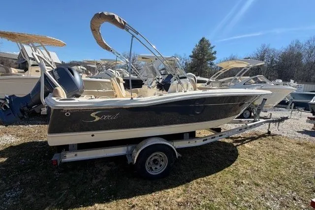 Slide: The Image of 2022 Scout 195 Sport Dorado boat on trailer, parked outdoors under clear sky. - 2
