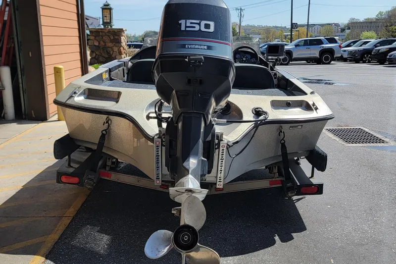 Slide: The Image of 1995 Ranger boat with Evinrude 150 outboard motor, parked on a trailer. - 15