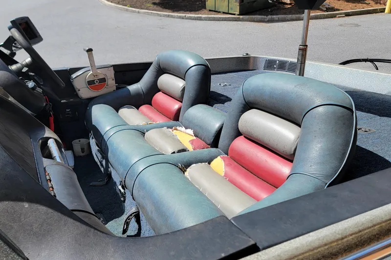Slide: The Image of Interior of a 1995 Ranger boat with worn, colorful seats and steering controls. - 5