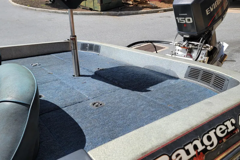 Slide: The Image of 1995 Ranger boat with Evinrude 150 engine, blue carpeted deck, and seating area. - 6