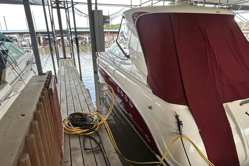 Slide: The Image of 2010 Chaparral Signature 370 docked with maroon cover, marina background. - 11