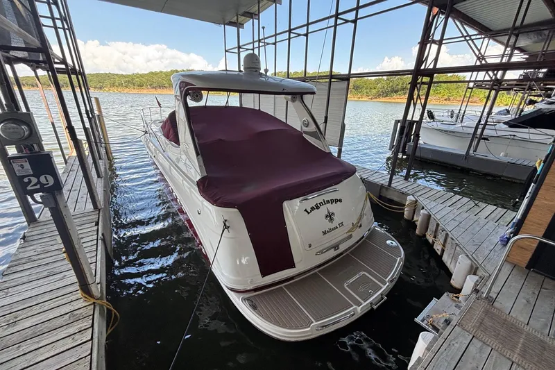 Slide: The Image of 2010 Chaparral Signature 370 boat docked, covered in maroon, at a lakeside marina. - 22
