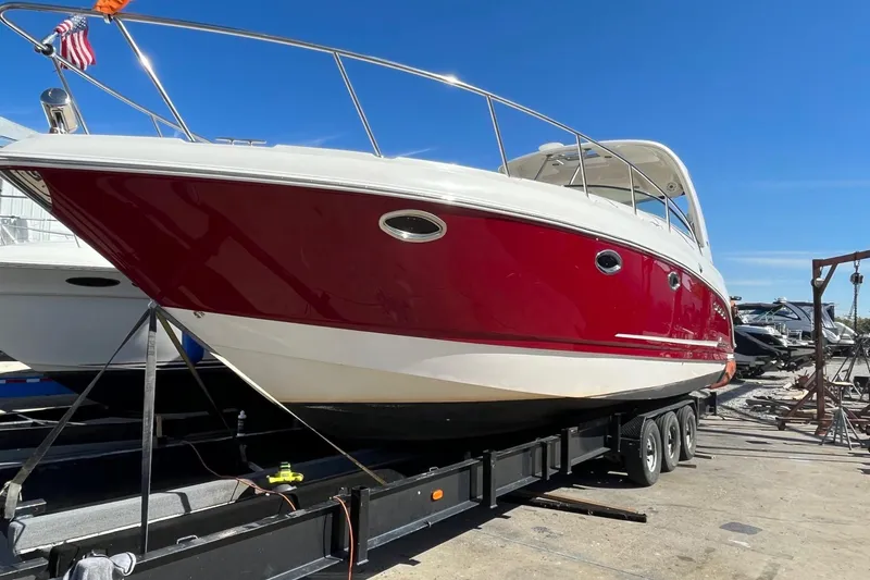 Slide: The Image of 2010 Chaparral Signature 370 boat with red hull on trailer, sunny day. - 36