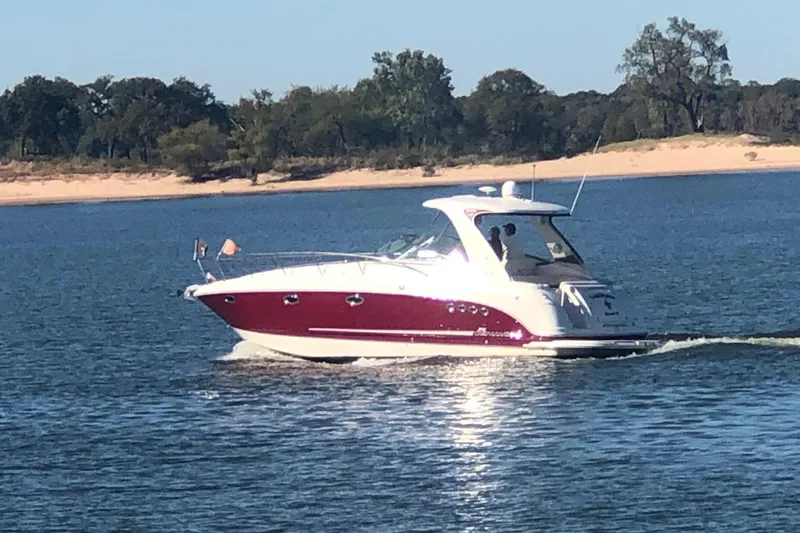 Slide: The Image of 2010 Chaparral Signature 370 cruising on a serene lake with a sandy shoreline. - 5