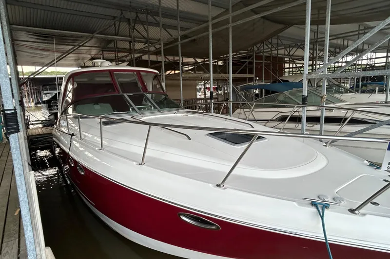 Slide: The Image of 2010 Chaparral Signature 370 boat docked in a marina, featuring a sleek red and white design. - 7