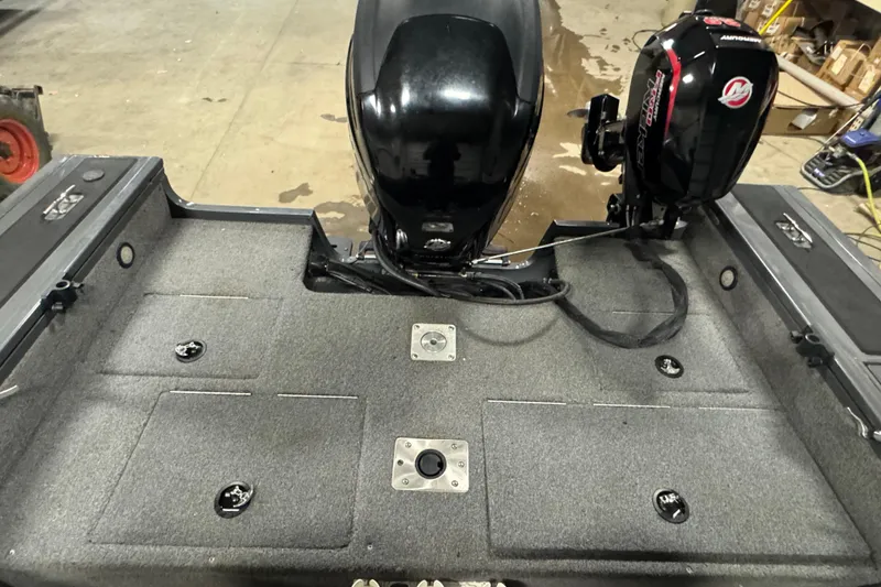 Slide: The Image of 2017 Tracker Targa V-18 WT boat interior with motor, gray carpeted deck. - 10