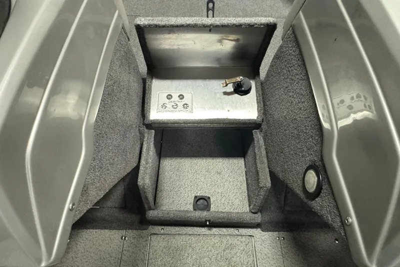 Slide: The Image of 2017 Tracker Targa V-18 WT boat interior with storage compartment and carpeted flooring. - 11