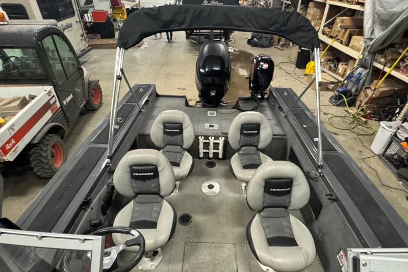 Slide: The Image of 2017 Tracker Targa V-18 WT boat interior with seating and motor in a workshop. - 15