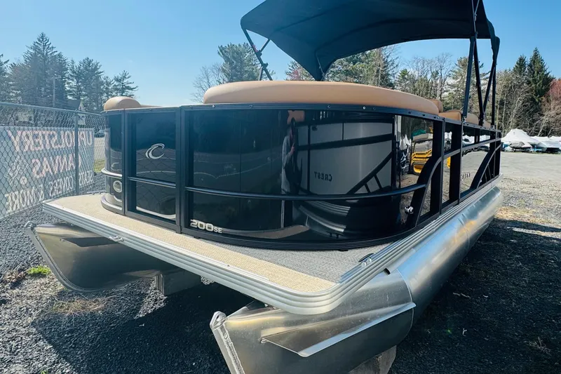 Slide: The Image of 2026 Crest Conquest SE 200 Cruise pontoon boat with sleek black exterior and canopy. - 2