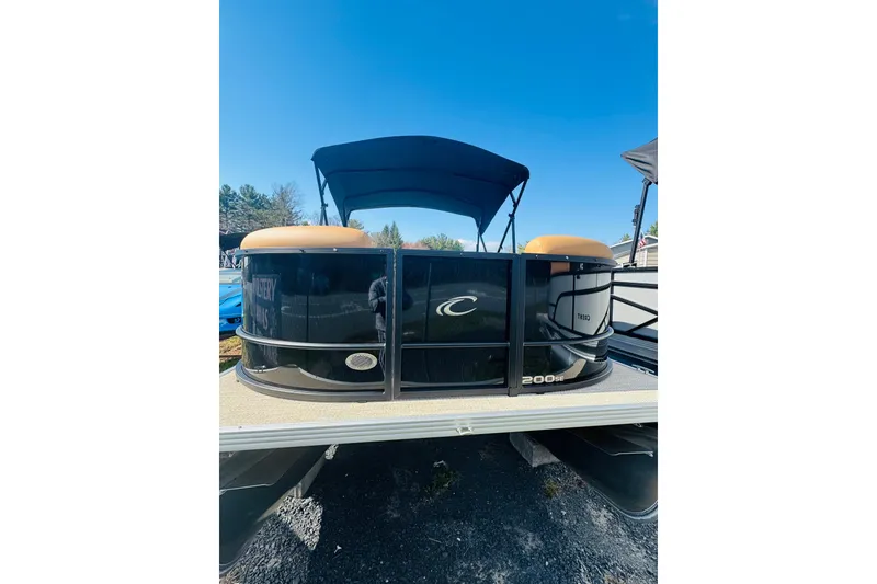 Slide: The Image of 2026 Crest Conquest SE 200 Cruise pontoon boat with canopy, parked outdoors. - 3