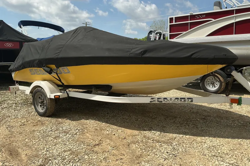 Slide: The Image of 2005 Sea-Doo Sportster boat with cover on trailer, parked outdoors. - 11