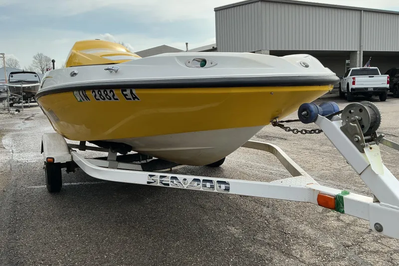 Slide: The Image of 2005 Sea-Doo Sportster boat on trailer, yellow and white, parked outdoors. - 3