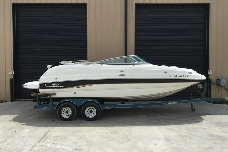 The Image of 2005 Chaparral Sunesta 216 boat on trailer, parked outside a garage. - 1