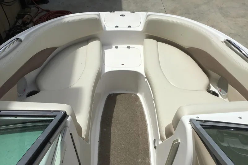 Slide: The Image of 2005 Chaparral Sunesta 216 boat interior with beige seating and carpeted floor. - 12