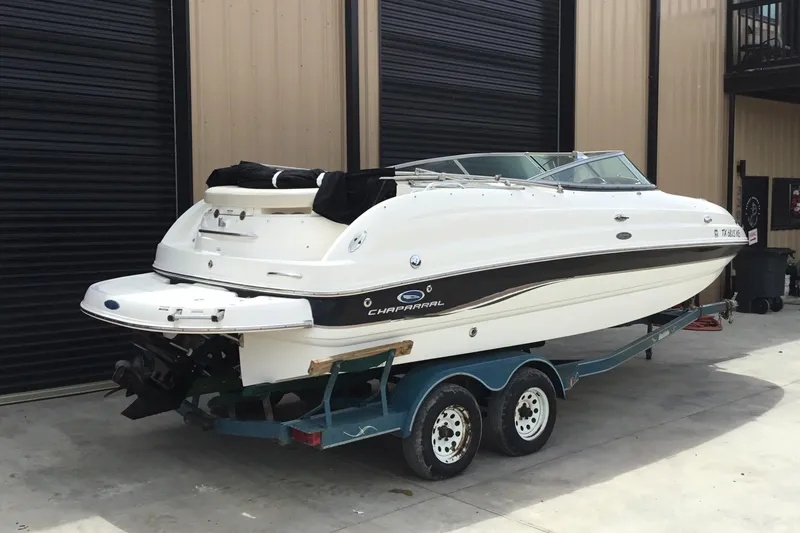 Slide: The Image of 2005 Chaparral Sunesta 216 boat on trailer, parked outside a garage. - 4