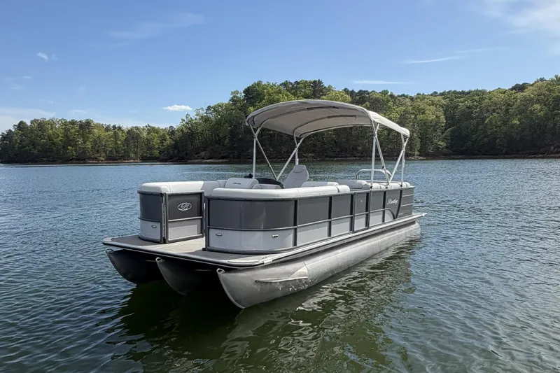 The Image of 2022 Bentley Pontoons 240 Cruise XL Legacy on serene lake with lush forest backdrop. - 1
