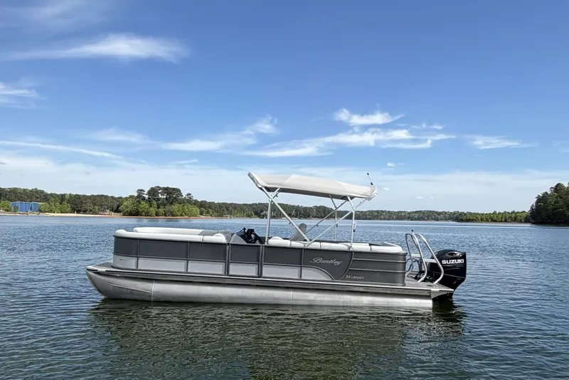 Slide: The Image of 2022 Bentley Pontoons 240 Cruise XL Legacy on a serene lake under a clear blue sky. - 9