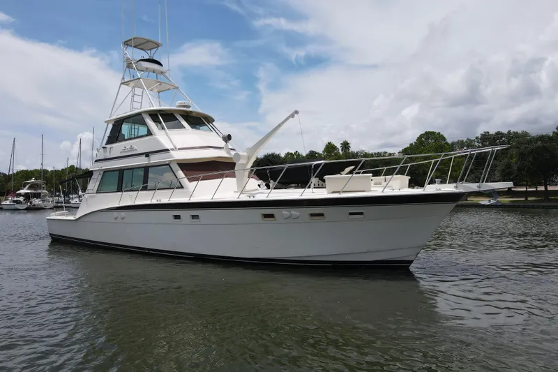 Slide: The Image of 1985 Hatteras 60 Convertible yacht on calm water under a cloudy sky. - 14