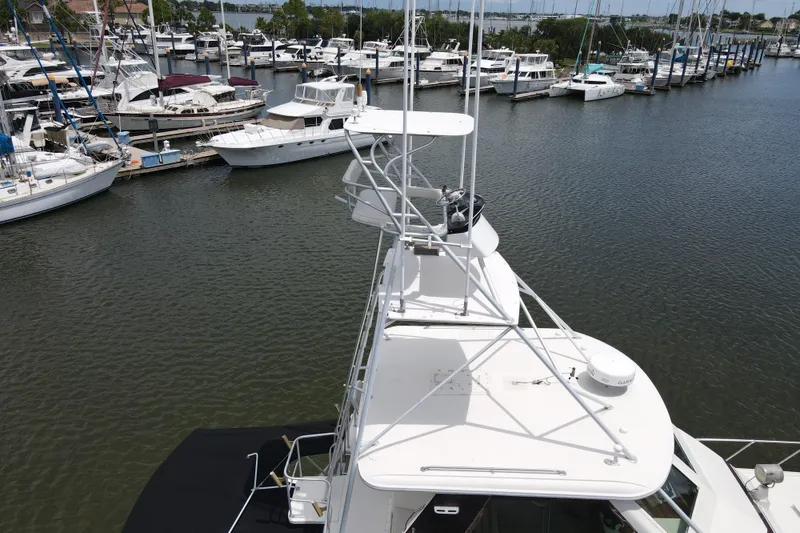 Slide: The Image of 1985 Hatteras 60 Convertible yacht docked at marina with other boats. - 15
