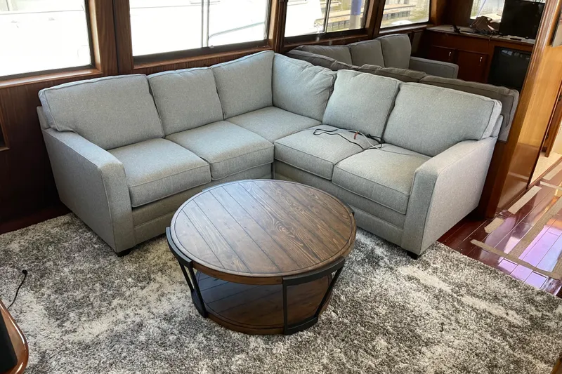 Slide: The Image of Gray sectional sofa and round wooden table in 1985 Hatteras 60 Convertible yacht interior. - 18
