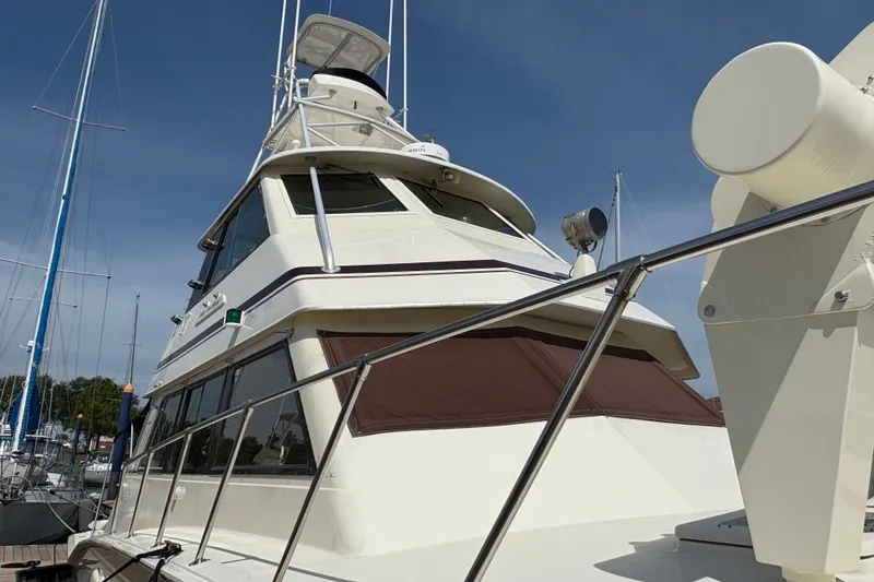 Slide: The Image of 1985 Hatteras 60 Convertible yacht docked under clear blue sky. - 21